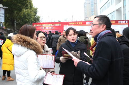 图为：泰兴市2019年新春人才招聘会暨人才交流洽谈会现场求职者交流2