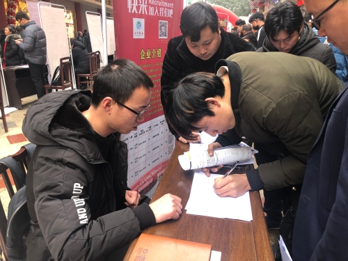 彝族小伙克惹拉机正在认真填写就业意向登记表